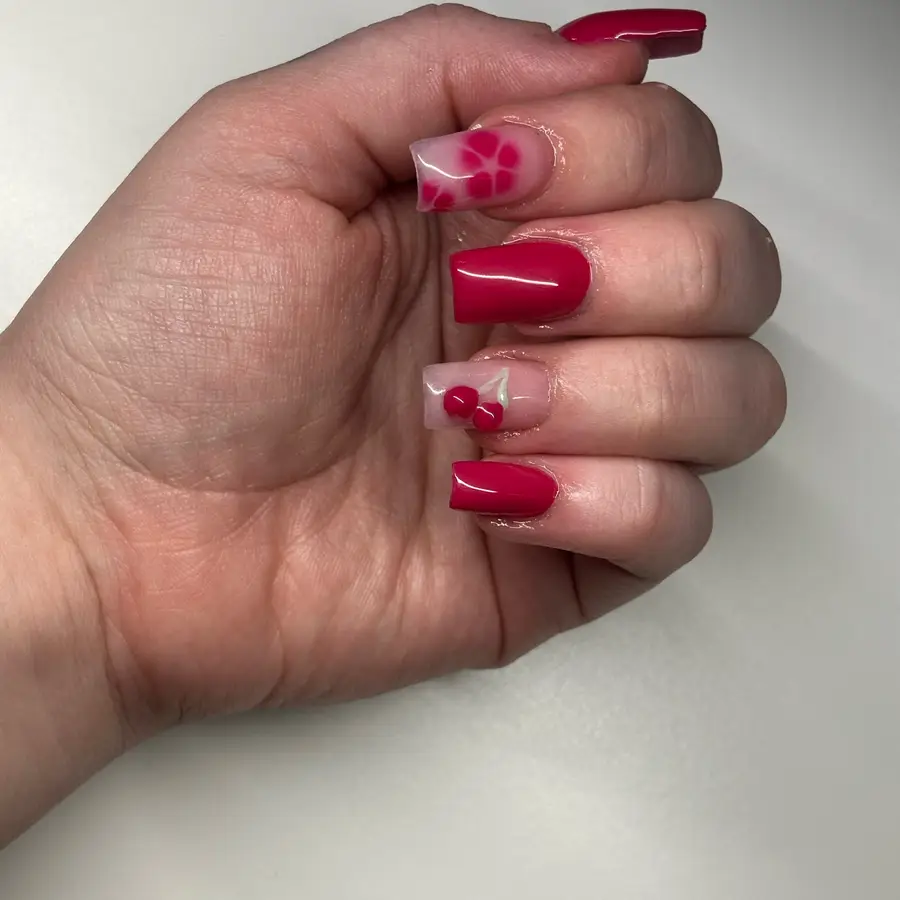 Square nails in raspberry pink, with a raised cherry design on one nail and a pink citrus slice on another.
